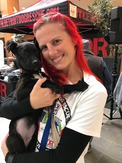 Amy Z of DMCU holds a black shelter puppy at the Donate for Dogs radiothon